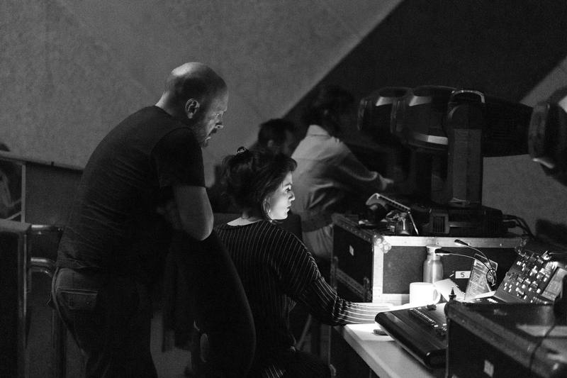 En noir et blanc, deux personnes penchées sur une console d'enregistrement dans un studio.